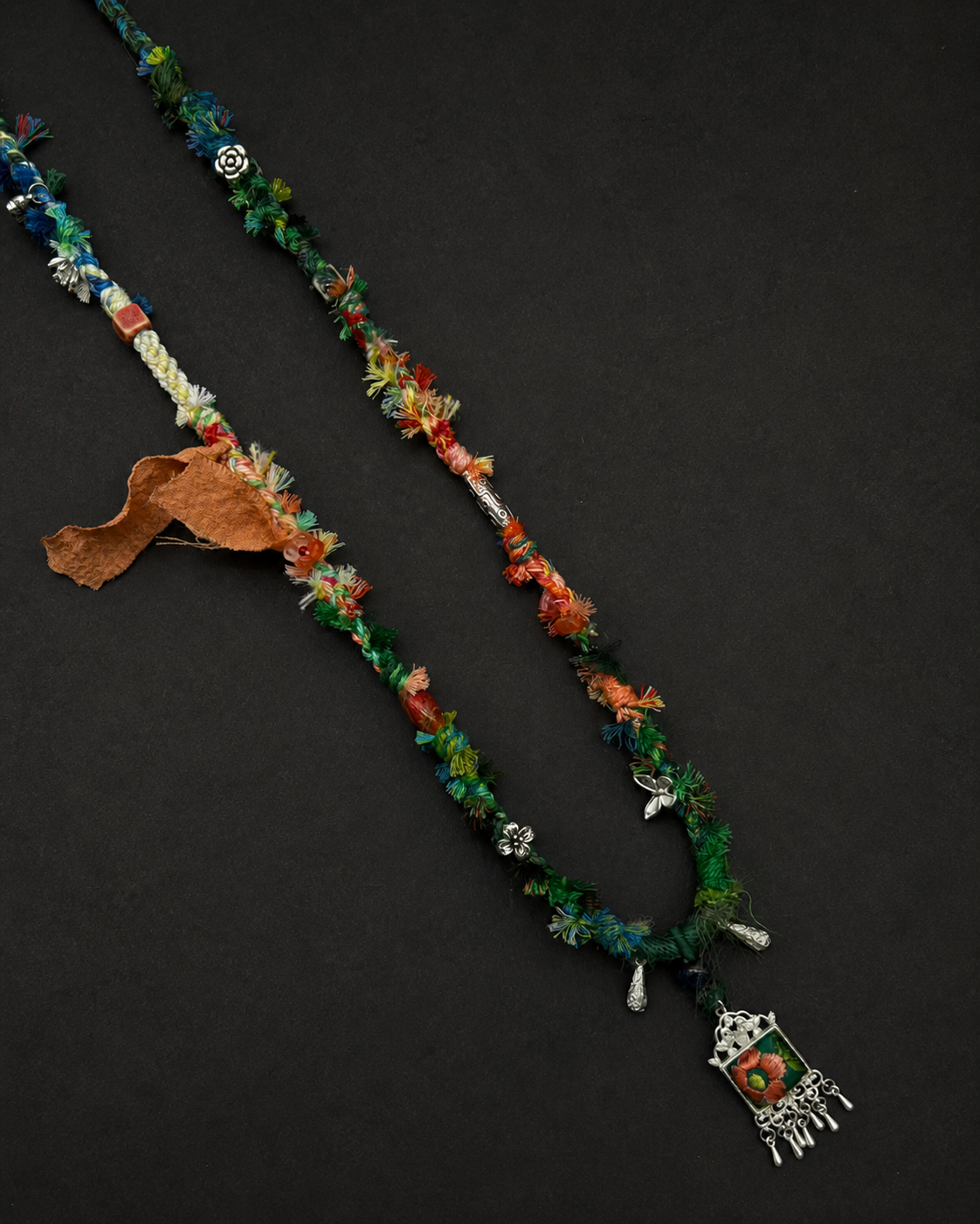 Green-led multicolour braided necklace with a framed floral pendant